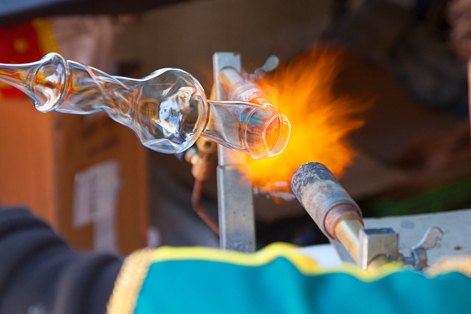 A torch flame heating glass in a glassworking studio