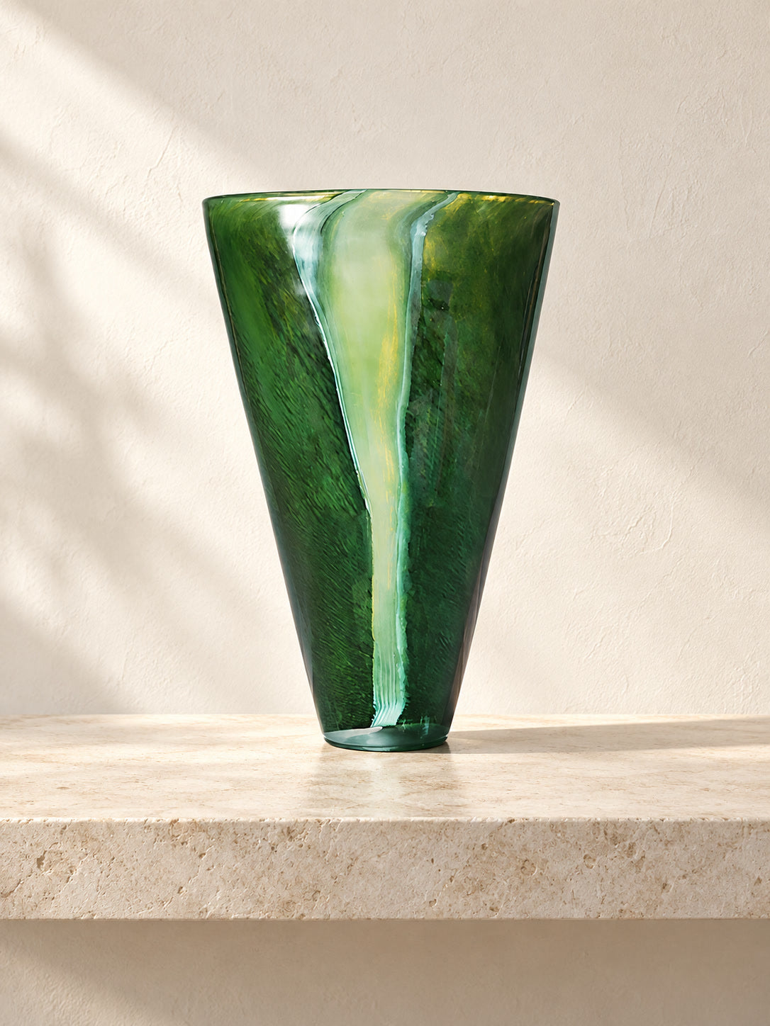 Forest Stream green glass vase with flowing pale accents in a limestone gallery setting